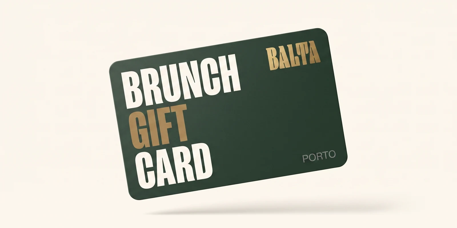 A Balta Brunch gift card, wrapped, on the wooden table beside a coffee