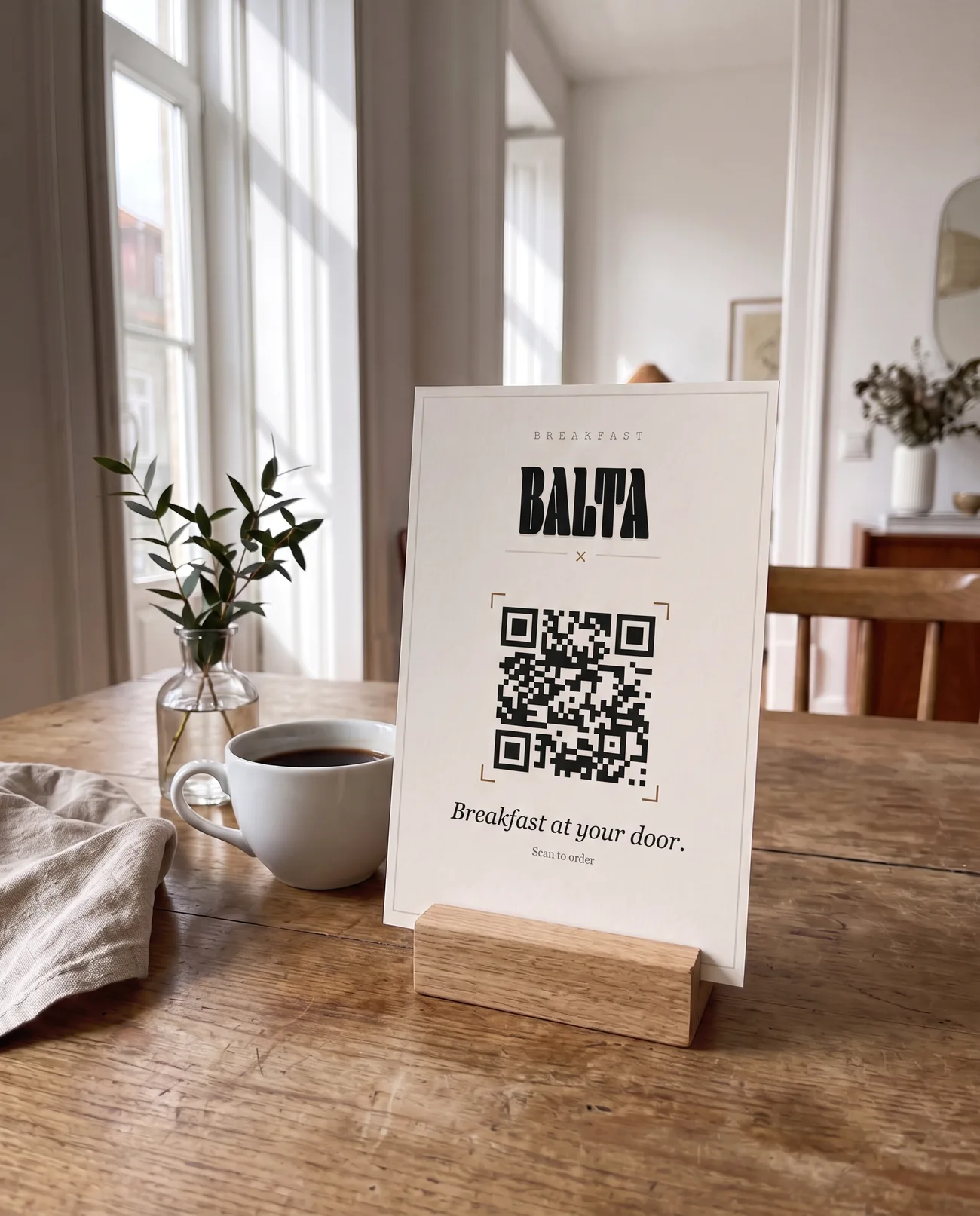Balta card with the QR code for ordering breakfast, in a wooden holder on a table in a rental